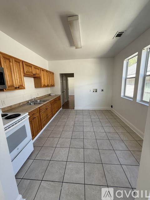 A kitchen with white appliances and wooden cabinets.