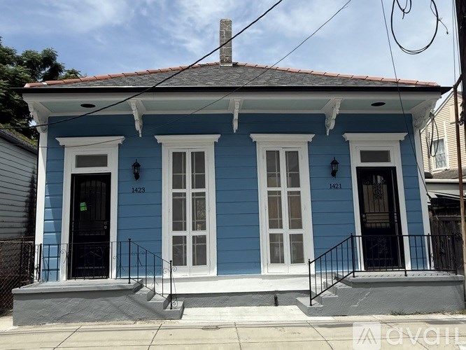 A blue house with white trim and a black door.