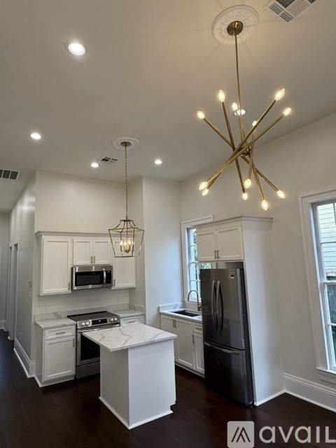 A kitchen with a black fridge and a white island.