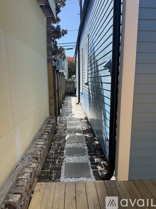 A narrow alley with a wooden walkway and a brick base.