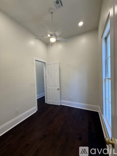 A room with a ceiling fan and a door.