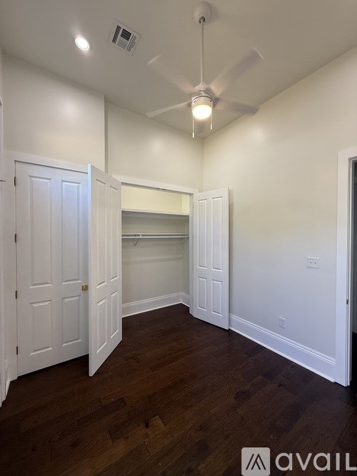 A room with a ceiling fan and a doorway leading to another room.