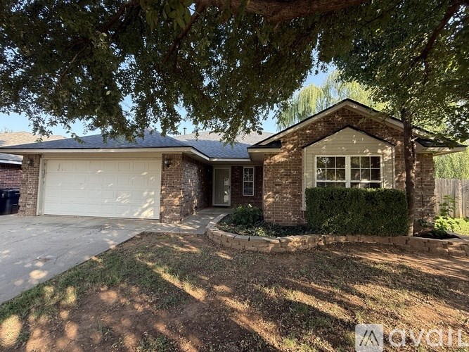 A house with a white garage door is surrounded by trees.