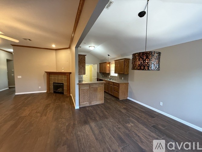 A spacious living room with wood flooring and a fireplace.