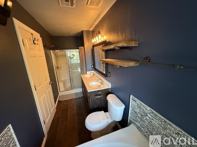 A bathroom with a toilet, sink, and mirror.