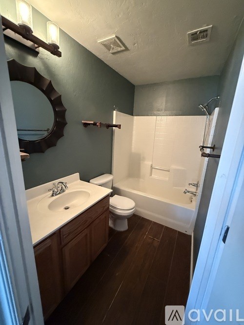 A bathroom with a white sink and toilet.
