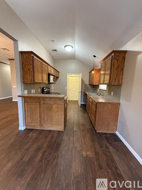 A kitchen with wooden cabinets and a white door in the middle.