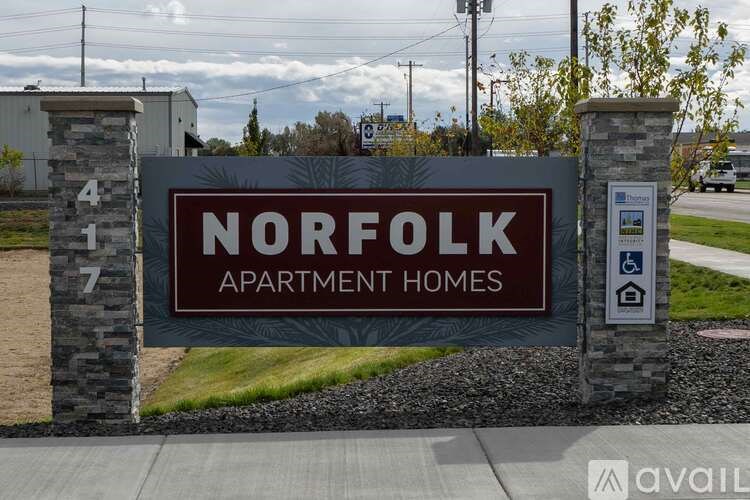 A sign for Norfolk Apartment Homes is displayed in front of a building.