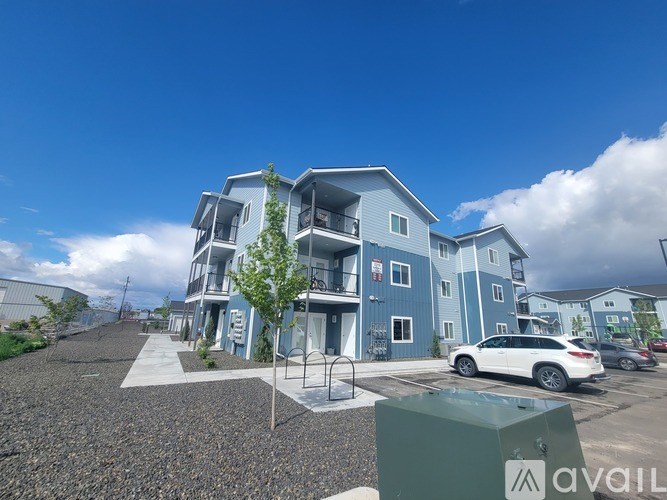 A modern apartment complex with a parking lot in front.