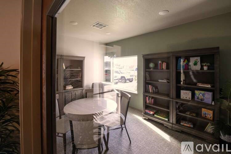 A room with a table and chairs and a bookshelf.