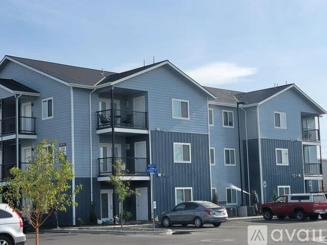 Apartment building with cars parked in front.
