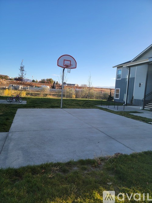 A basketball hoop stands in the middle of a concrete court.