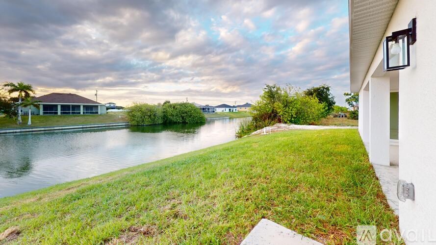 A house with a lawn and a body of water in the background.