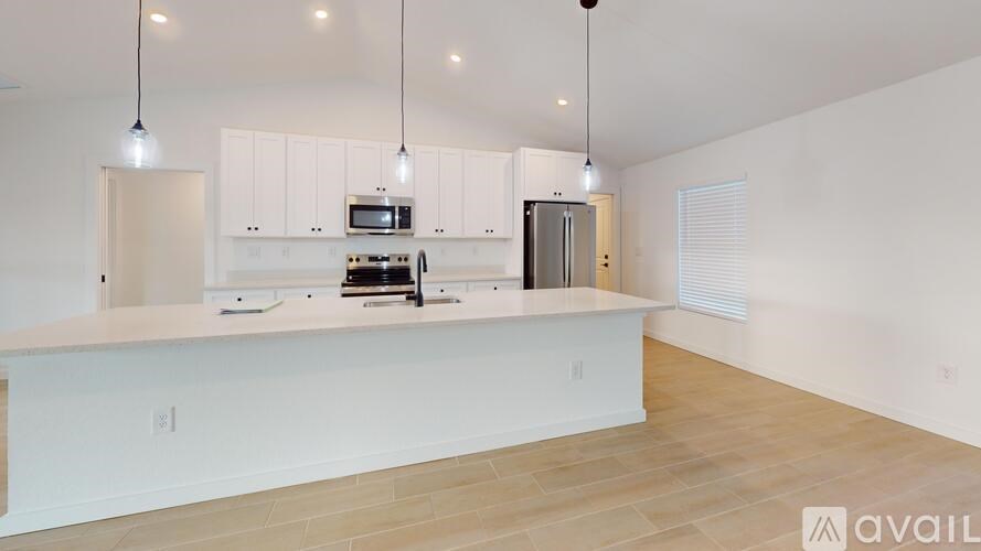 A kitchen with white cabinets and a wooden floor.