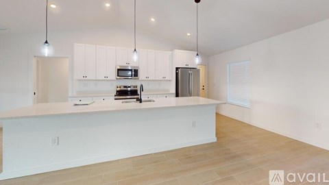 A kitchen with white cabinets and a wooden floor.