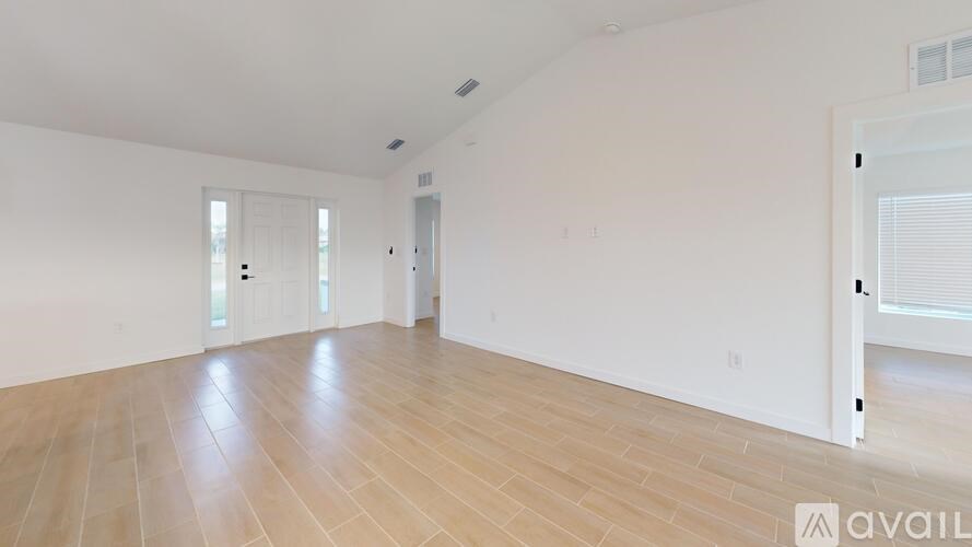Empty room with wooden flooring and white walls.
