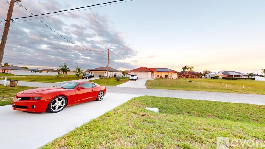 A red Chevrolet car is parked on a street.