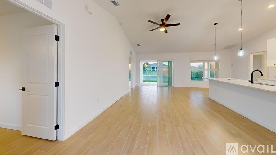 A spacious room with wooden flooring and a ceiling fan.