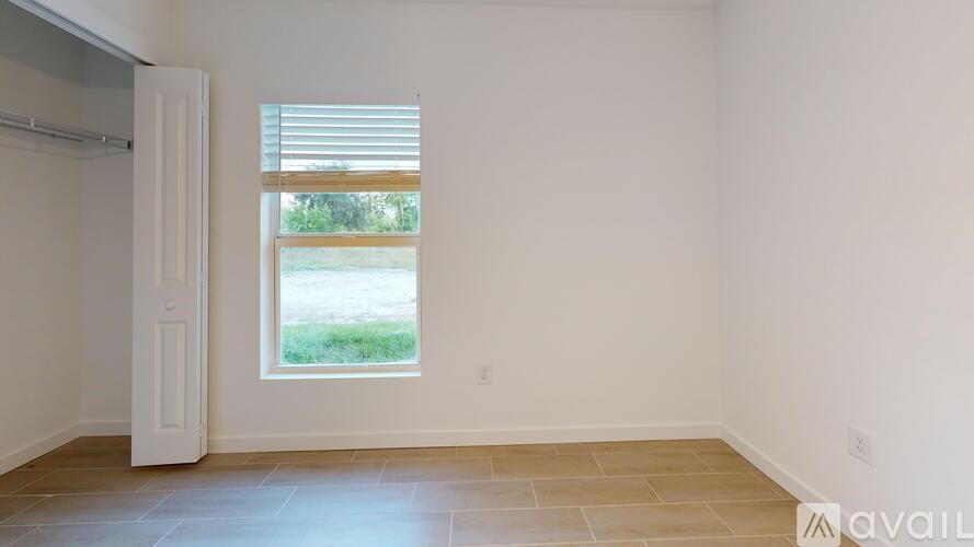 A room with a window and a door is available for rent.