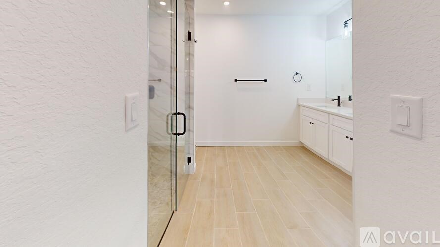 A bathroom with a walk-in shower and a white vanity.