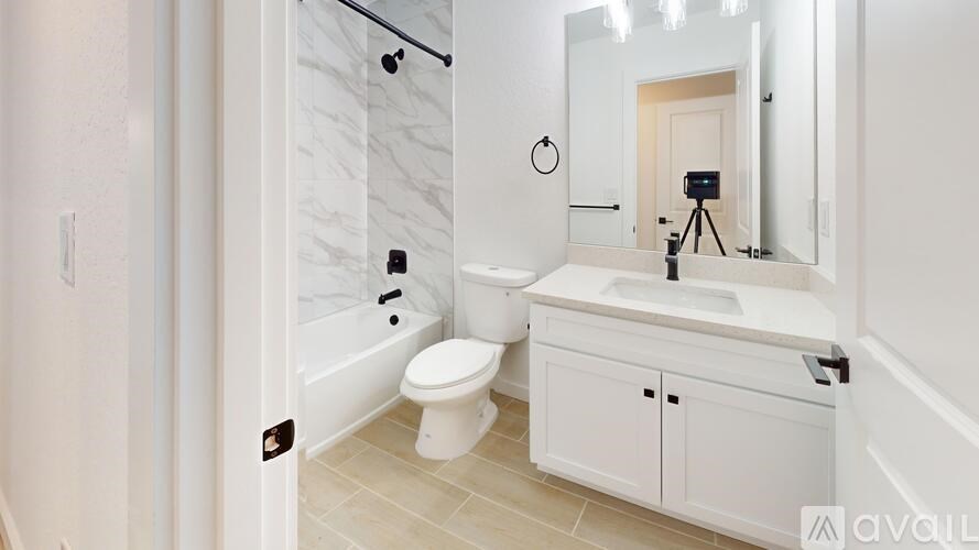 A bathroom with a white toilet, sink, and cabinets.