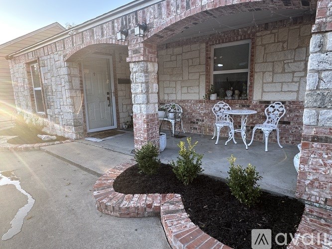 A patio with a table and chairs is surrounded by a brick wall.