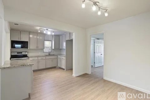 A kitchen with white cabinets and a countertop with a microwave on it.