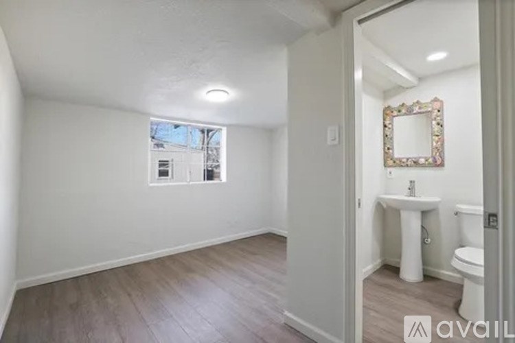 A bathroom with a toilet, sink, and mirror.