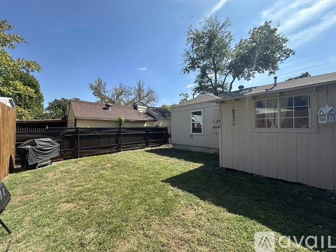 A backyard with a fence and a house.