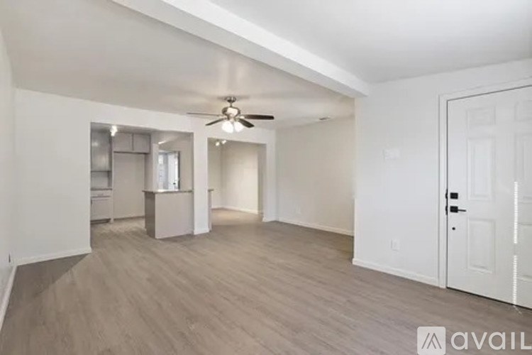 A spacious room with a ceiling fan and lighting fixture.