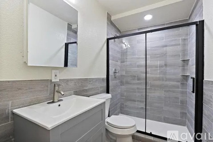 A bathroom with a sink, toilet, and glass shower door.