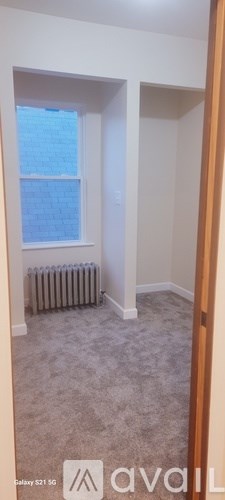A room with a window and a radiator on the floor.