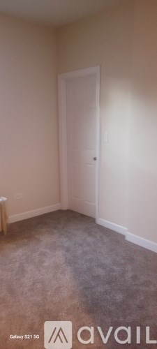 A room with a carpeted floor and a door.