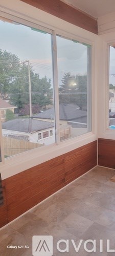 A room with a large window overlooking a residential area.