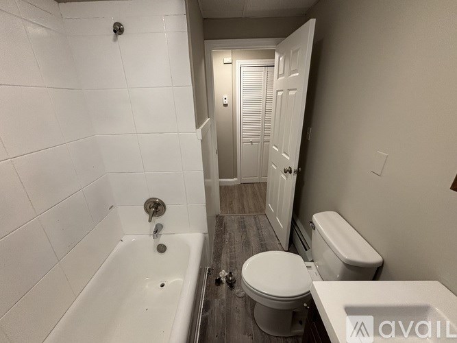 A bathroom with a white tub, toilet, and sink.