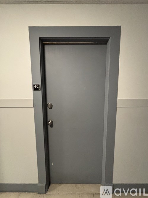 A grey door with a silver handle and a silver lock.