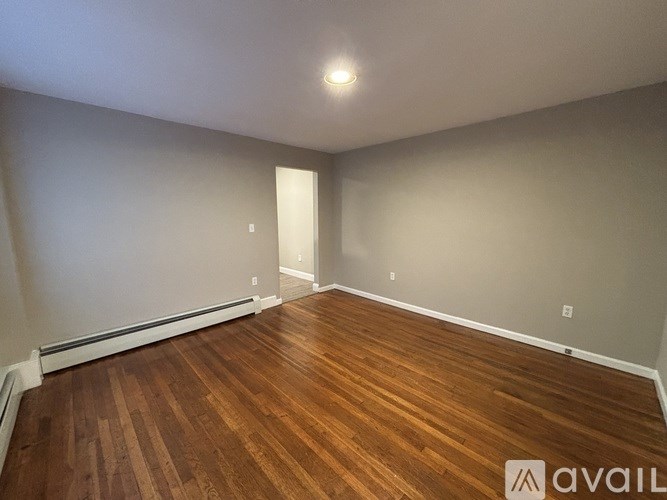 A room with wooden flooring and white walls.