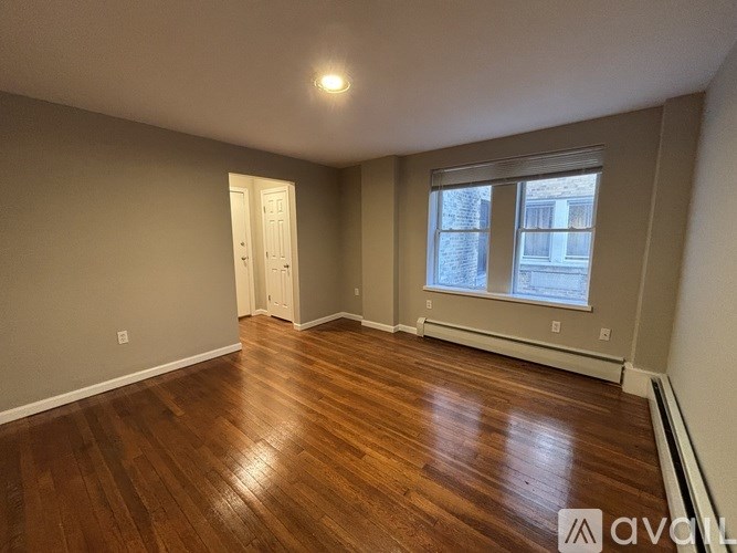 A room with wooden floors and a window showing a snowy scene outside.