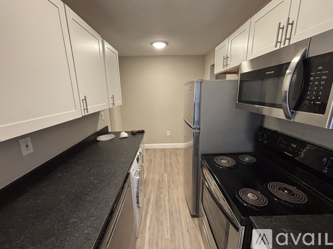 A kitchen with black countertops and stainless steel appliances.