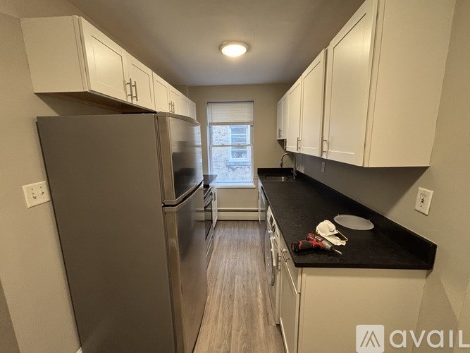 A kitchen with a black countertop and stainless steel appliances.