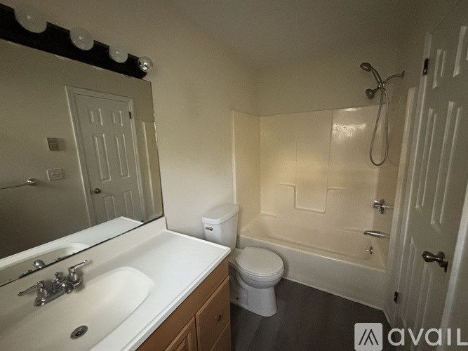 A bathroom with a white sink, toilet, and bathtub.