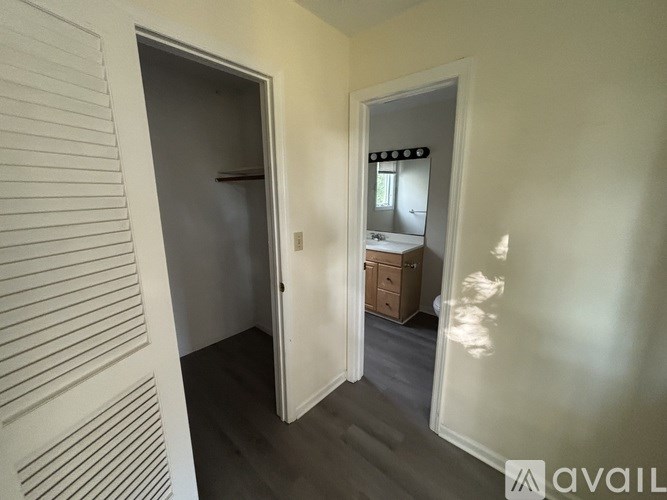 A room with a white door and a mirror on the wall.