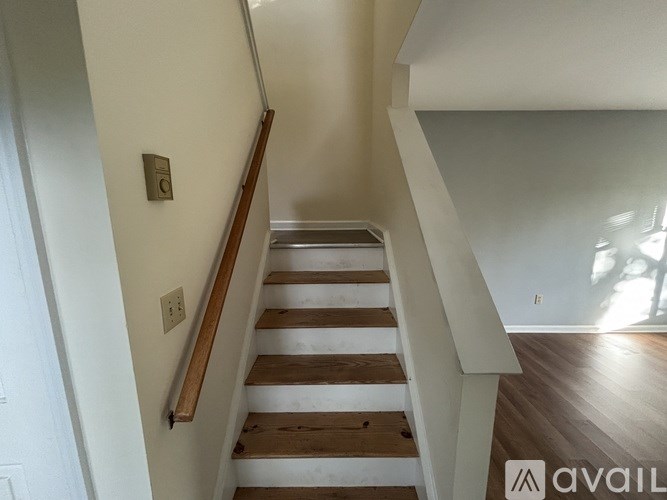 A staircase with wooden steps and a light switch on the wall.