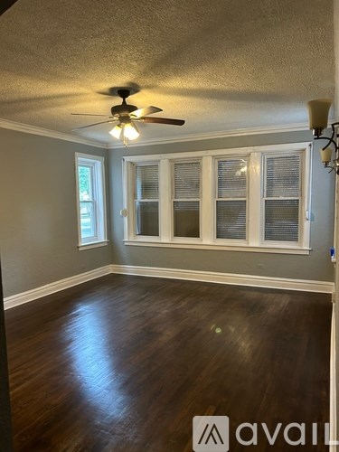 A room with a ceiling fan and wooden floors.