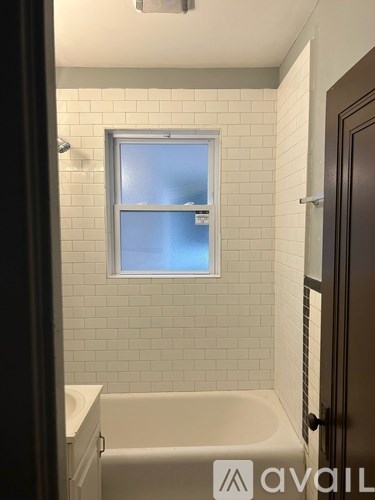 A bathroom with a white tub and a window.
