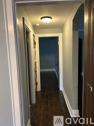 A hallway with a light on the ceiling and a door on the right.