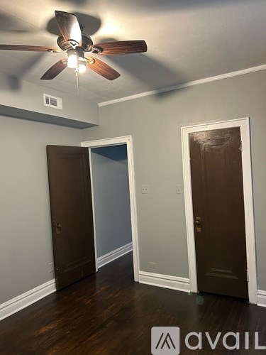 A room with a ceiling fan and two doors.
