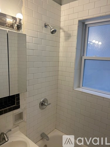 A bathroom with a white sink and a window.