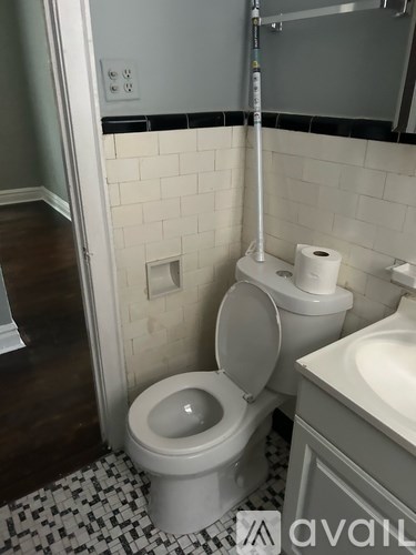 A toilet with a roll of toilet paper on top of it.