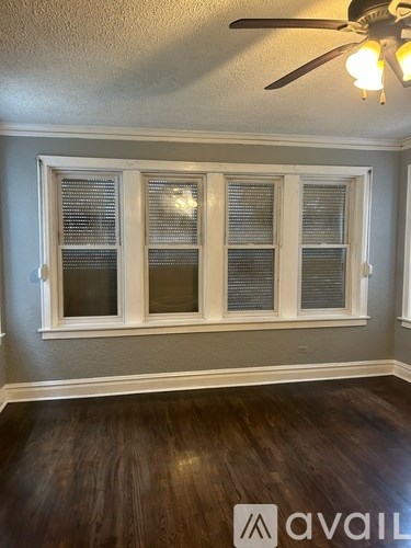 A room with a ceiling fan and a window with blinds.
